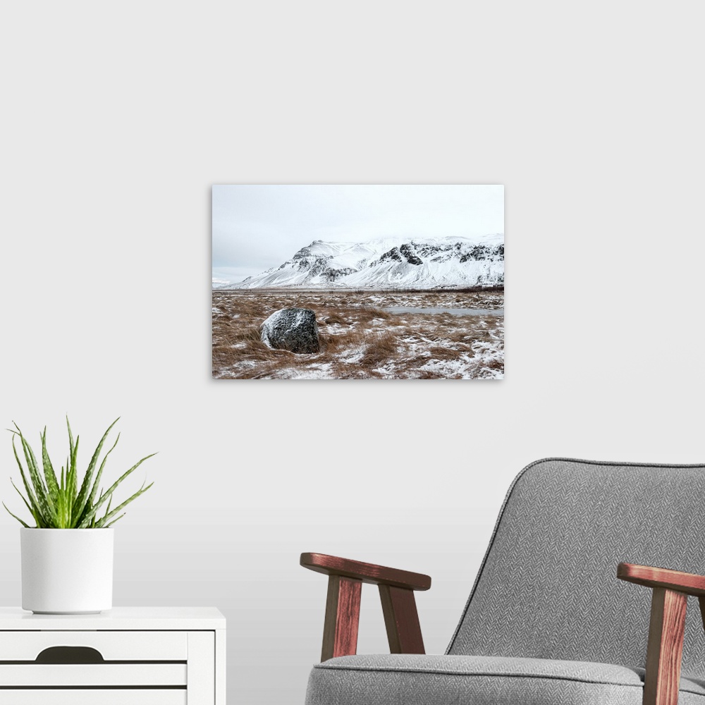 A modern room featuring A photograph of a mountain landscape partially covered in snow.