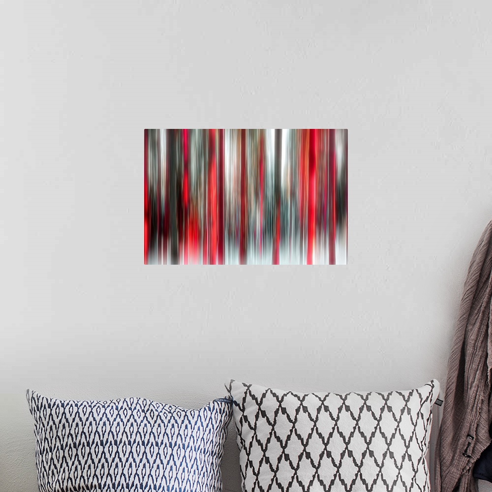 A bohemian room featuring An abstract photograph of a forest in red and black in a vertical motion blur.