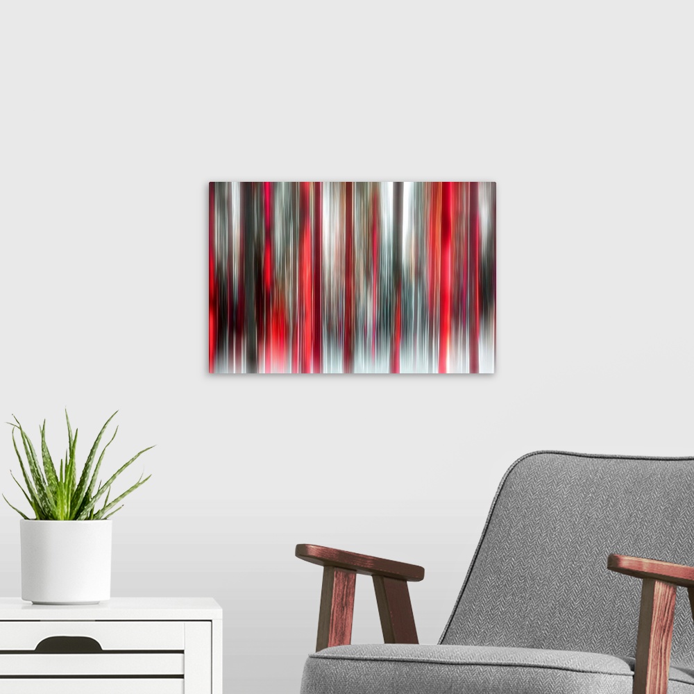 A modern room featuring An abstract photograph of a forest in red and black in a vertical motion blur.