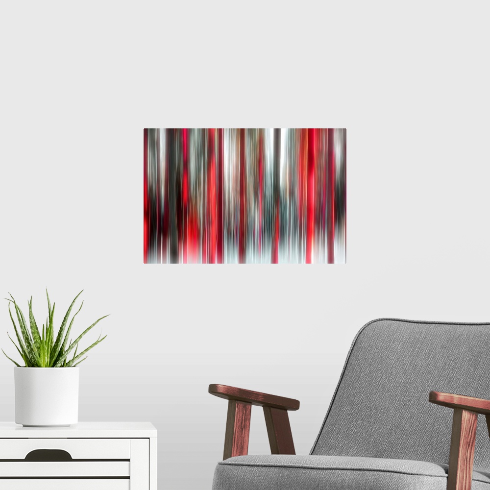 A modern room featuring An abstract photograph of a forest in red and black in a vertical motion blur.