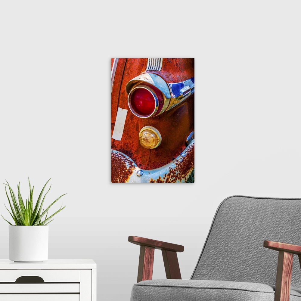 A modern room featuring A vivid surrealistic rusty red antique Pontiac tail light section with red and yellow lenses and ...