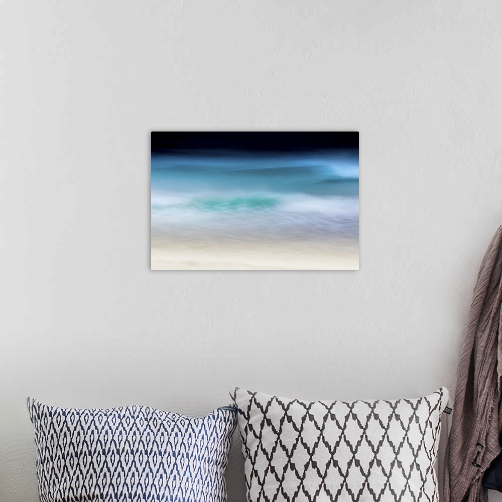 A bohemian room featuring Abstract seascape of teal waves breaking over soft sand with moody sky.