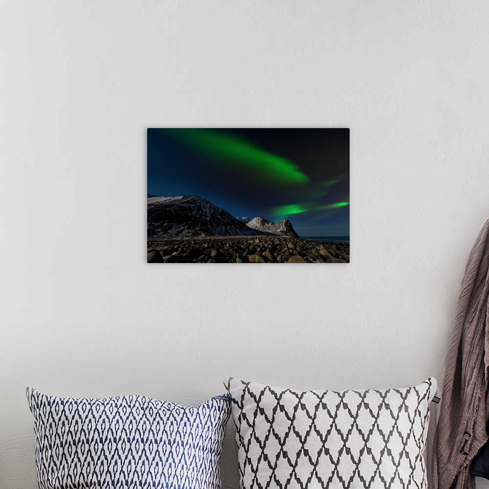 A bohemian room featuring A photograph of the northern lights over a snowy rugged landscape with mountains in the distance.