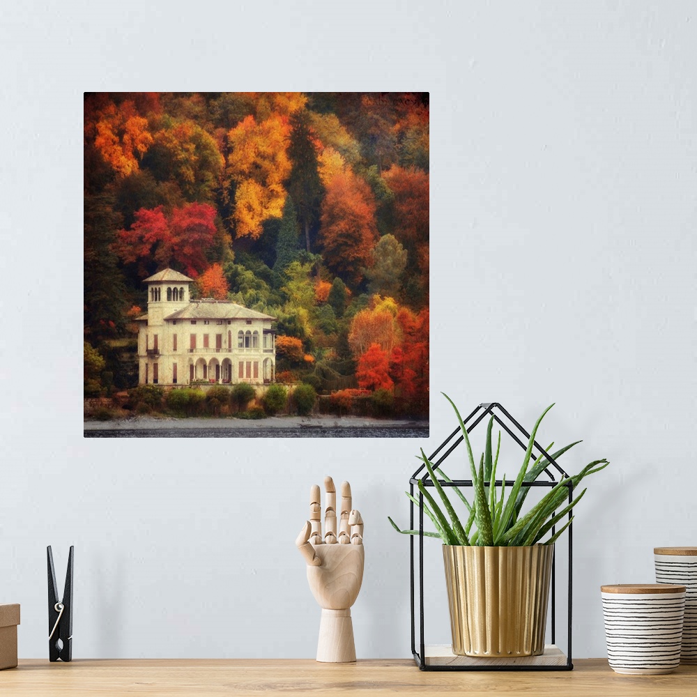 A bohemian room featuring This is a landscape photograph on square shaped wall docor that shows a lake side villa surrounde...