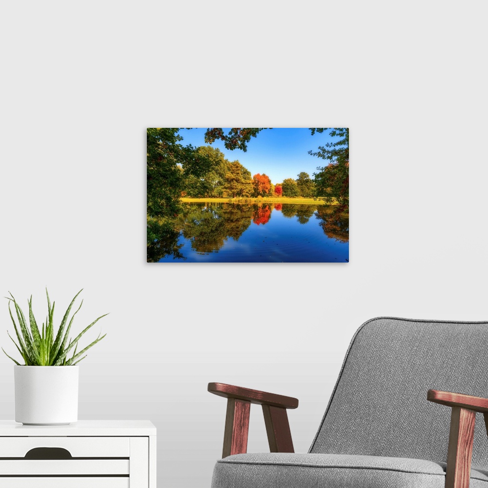A modern room featuring Nature in autumn around a pond
