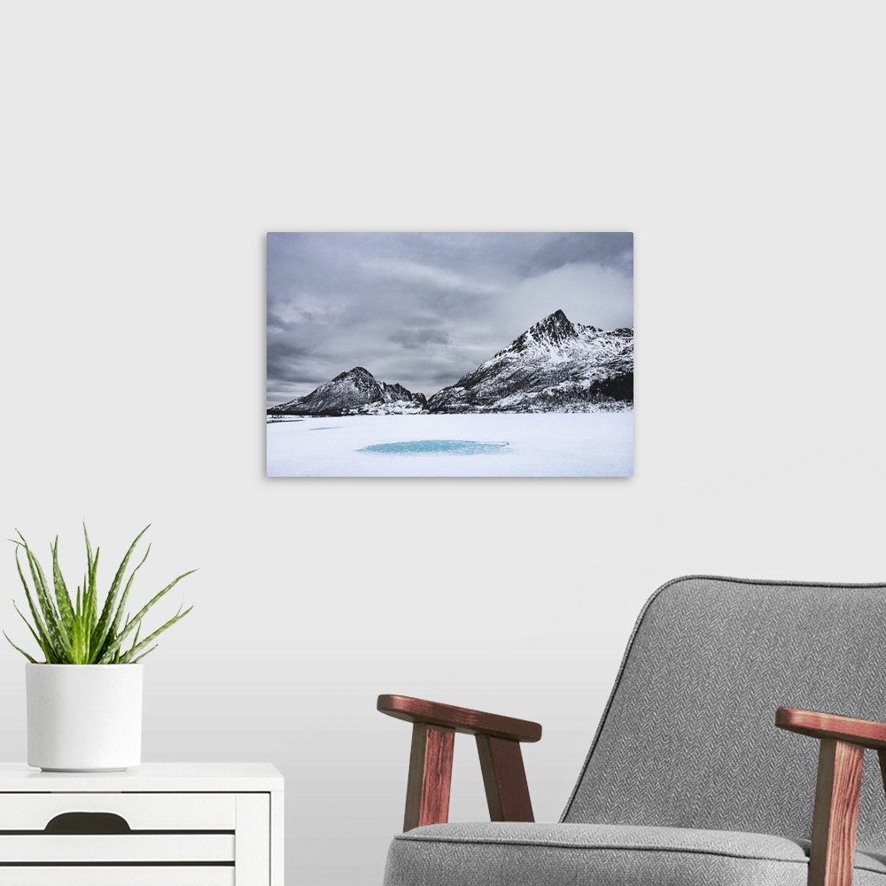 A modern room featuring Snow-covered landscape with mountains around a frozen lake