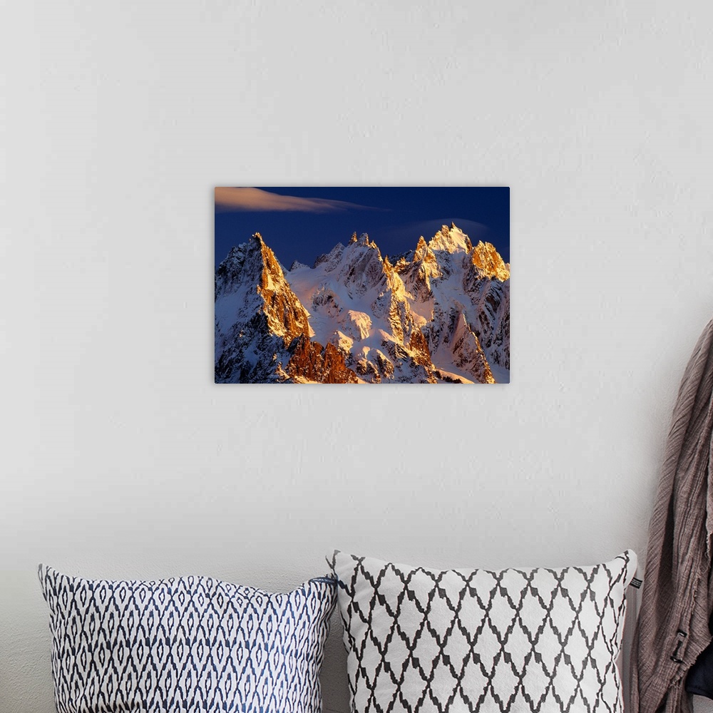 A bohemian room featuring Big photograph taken of snow covered mountains in the Alps of France.