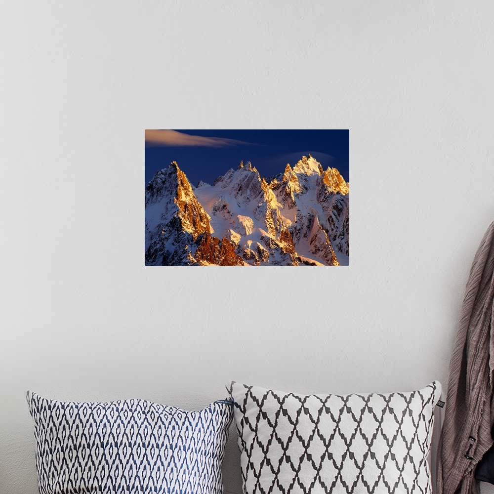 A bohemian room featuring Big photograph taken of snow covered mountains in the Alps of France.