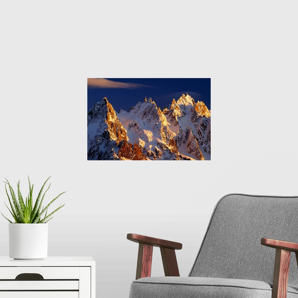 A modern room featuring Big photograph taken of snow covered mountains in the Alps of France.