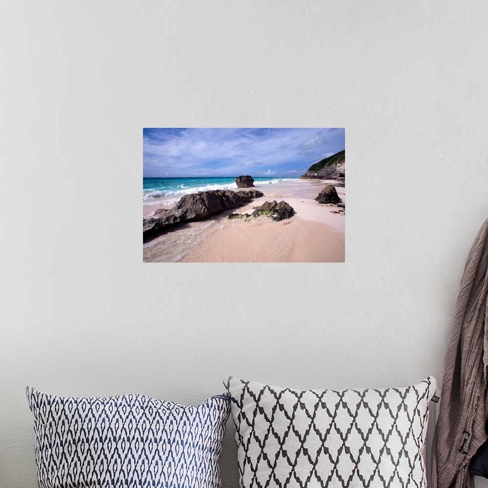 A bohemian room featuring View of a Pink Sand Shore, Elbow Beach, Bermuda, large rocks half-buried in the sand and foamy wa...