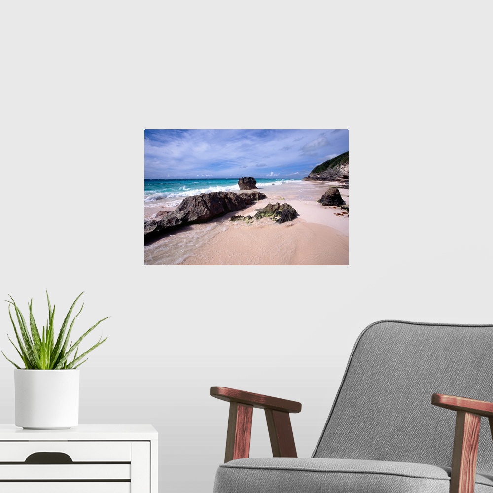 A modern room featuring View of a Pink Sand Shore, Elbow Beach, Bermuda, large rocks half-buried in the sand and foamy wa...