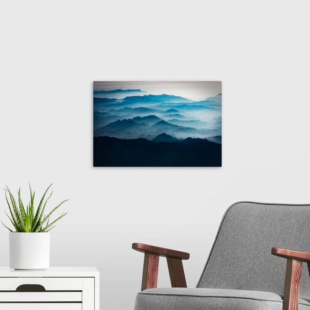 A modern room featuring Blue mountains with mist taken from the sky, mountains of Asia