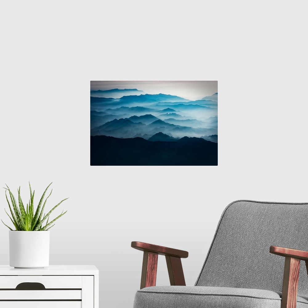 A modern room featuring Blue mountains with mist taken from the sky, mountains of Asia