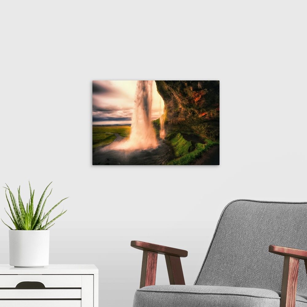 A modern room featuring View of the Seljalandsfoss Waterfall Behind from a Cave at Sunset, Iceland
