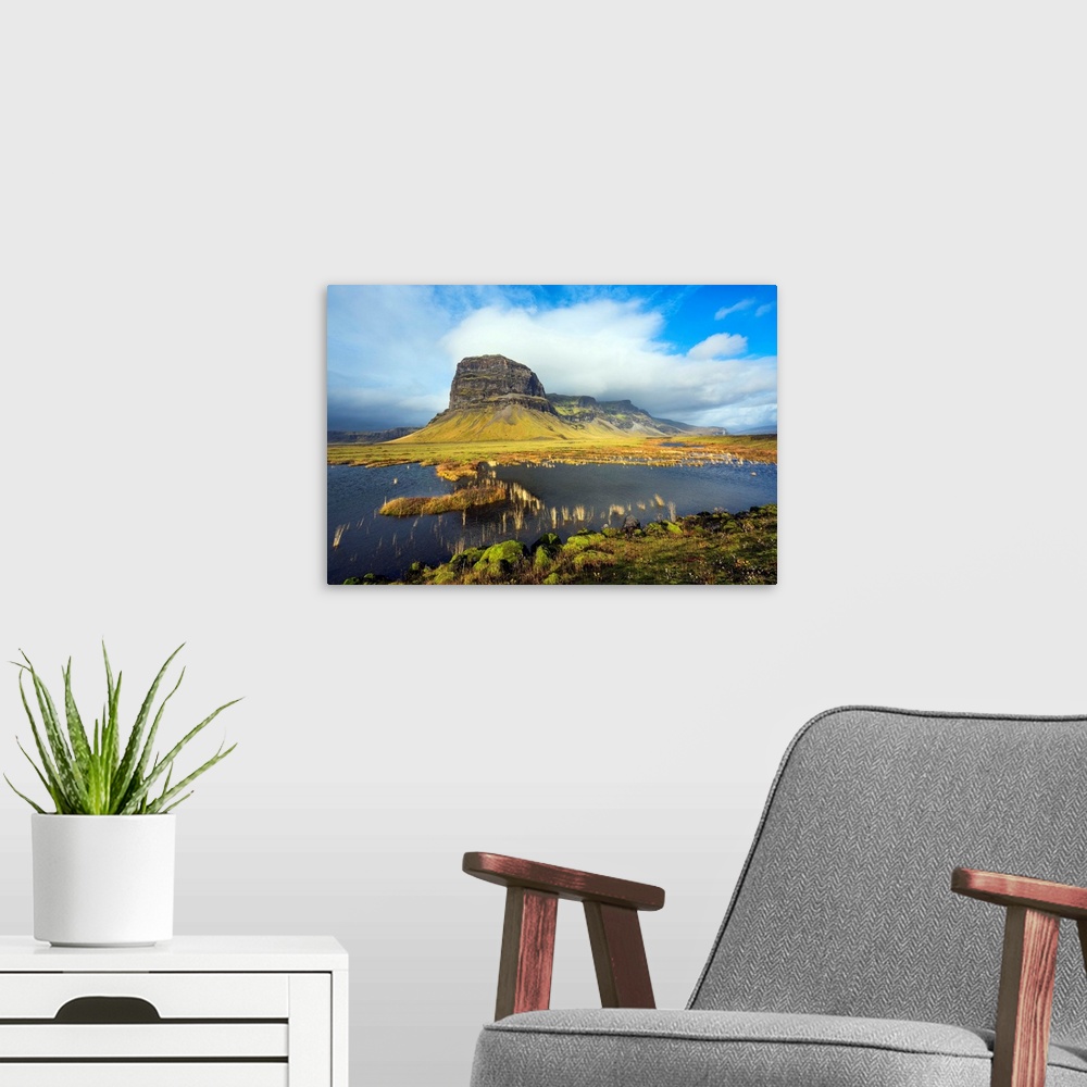 A modern room featuring Fine art photograph of the Icelandic landscape with a tall mountain surrounded by clouds.