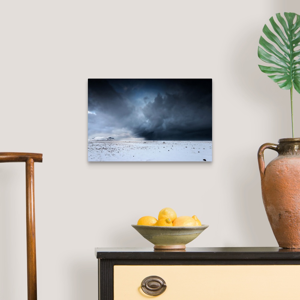 A traditional room featuring A photograph of a snowscape under a sky filled with dark rolling clouds.