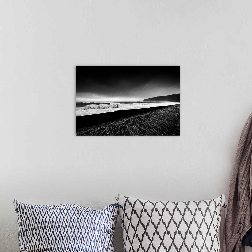A bohemian room featuring A black and white photograph of a coastal landscape.