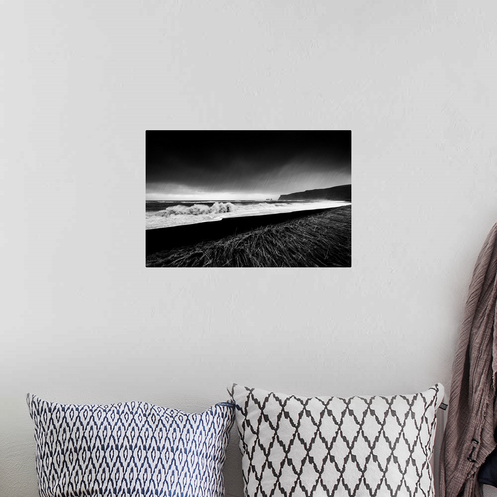A bohemian room featuring A black and white photograph of a coastal landscape.