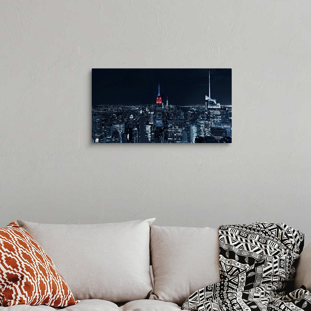 A bohemian room featuring Manhattan cityscape at night with a view straight on to the Empire state building.