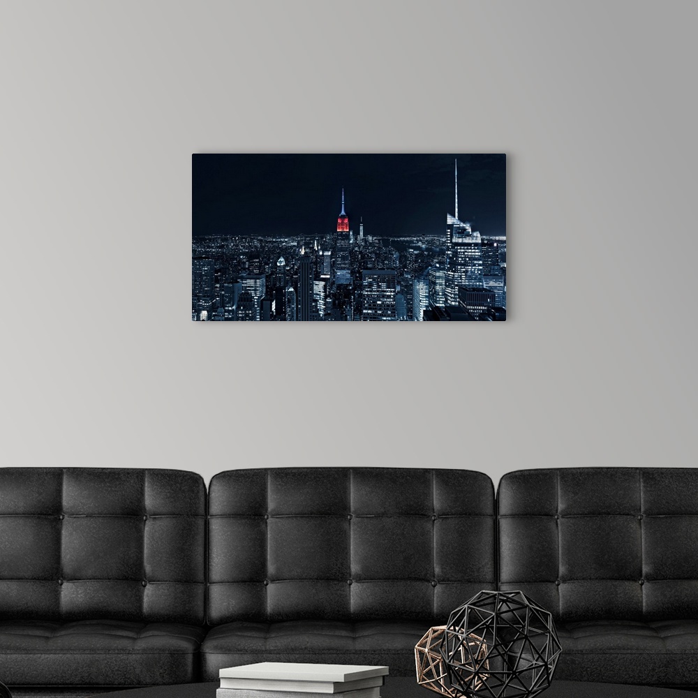 A modern room featuring Manhattan cityscape at night with a view straight on to the Empire state building.