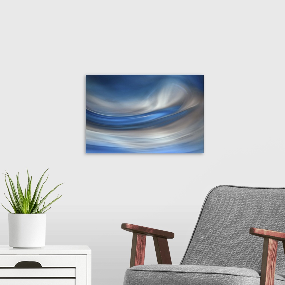 A modern room featuring Abstract photograph of blurred and blended colors and flowing lines in shades of blue and white.