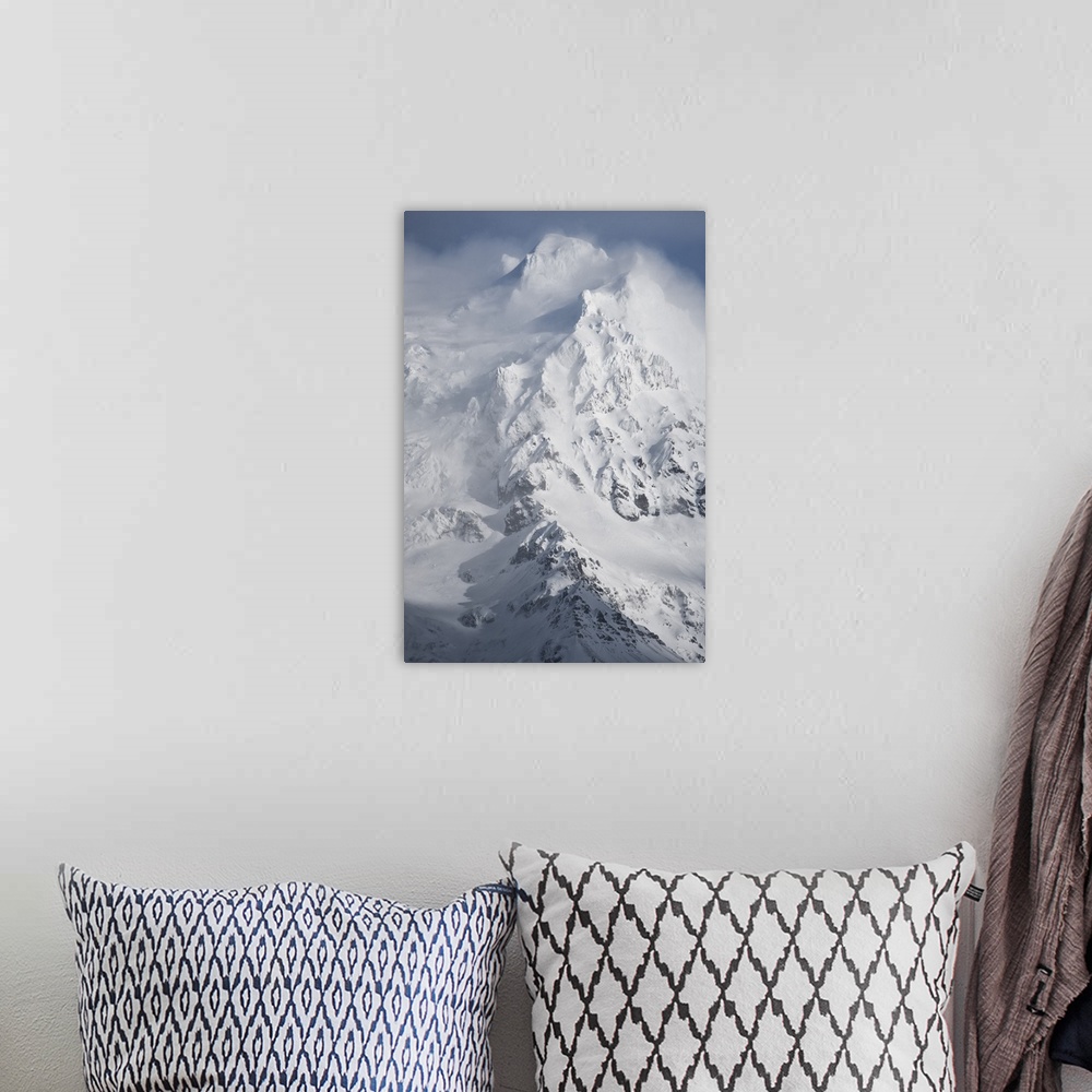A bohemian room featuring Clouds of snow billowing from the icy peak of a mountain.