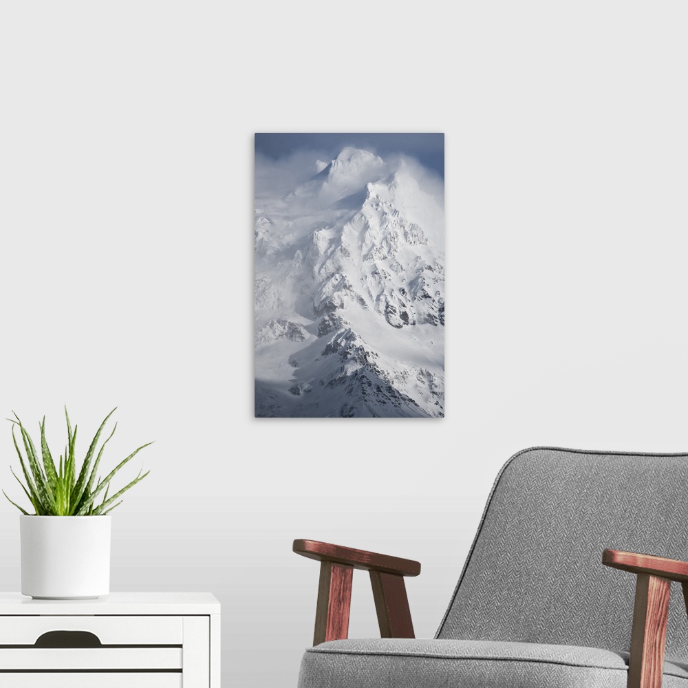 A modern room featuring Clouds of snow billowing from the icy peak of a mountain.