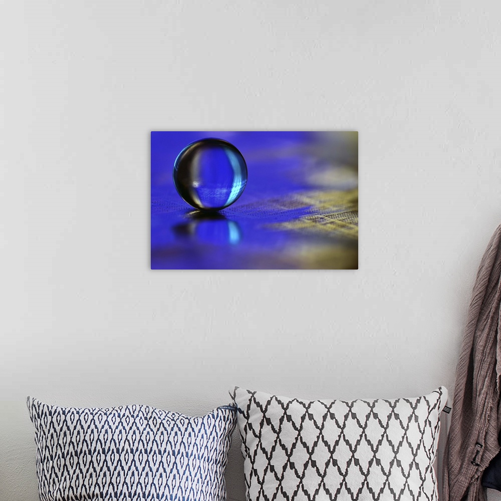 A bohemian room featuring A macro photograph of a water droplet sitting o a blue surface.