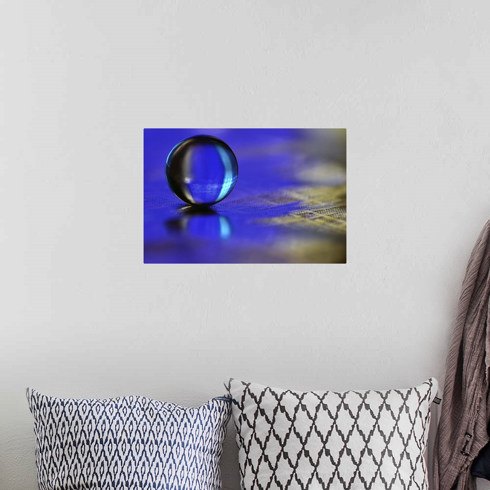 A bohemian room featuring A macro photograph of a water droplet sitting o a blue surface.
