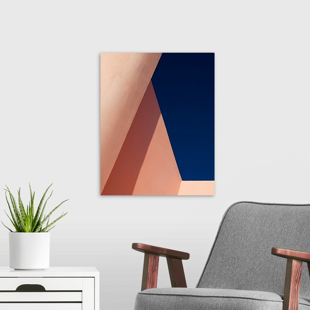 A modern room featuring Abstract angle view of pale pink walls against a deep blue sky.