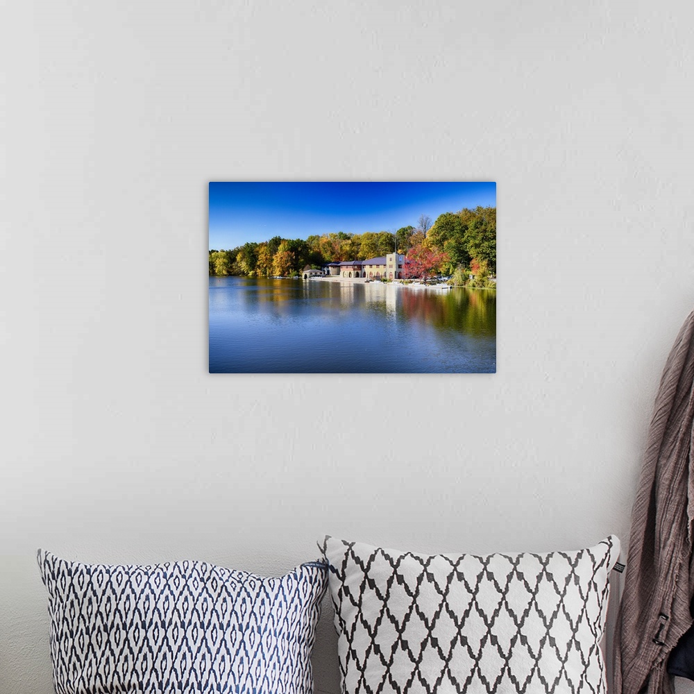A bohemian room featuring Buildings at the edge of the calm waters of Lake Carnegie in New Jersey in the fall.