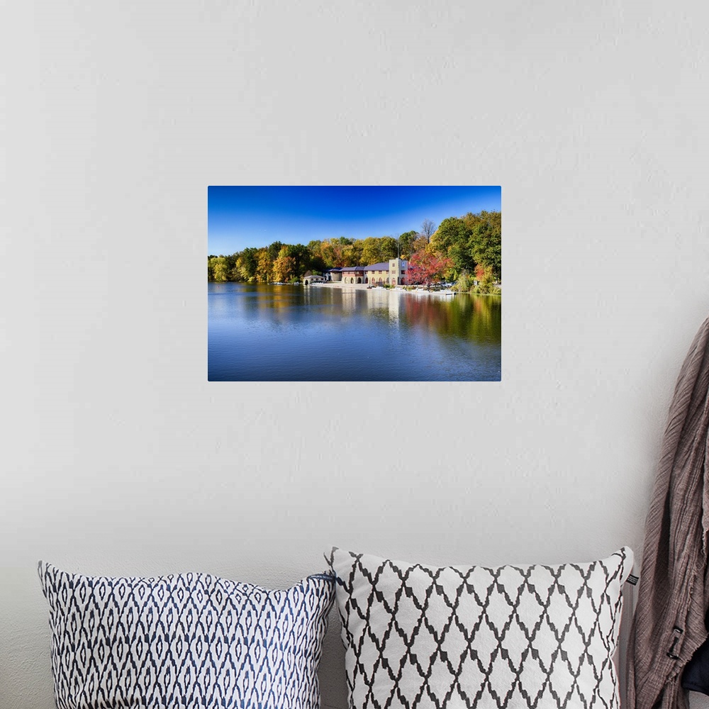 A bohemian room featuring Buildings at the edge of the calm waters of Lake Carnegie in New Jersey in the fall.