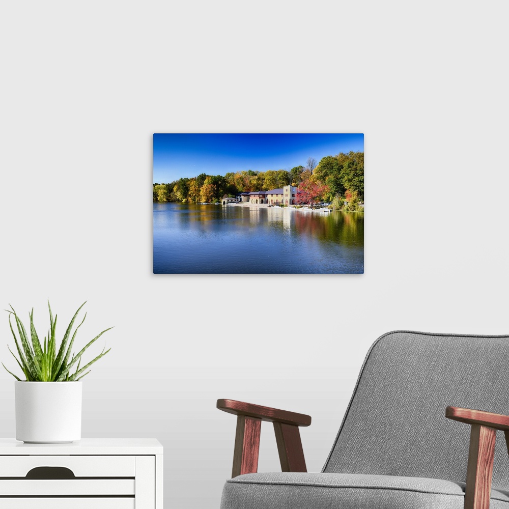 A modern room featuring Buildings at the edge of the calm waters of Lake Carnegie in New Jersey in the fall.