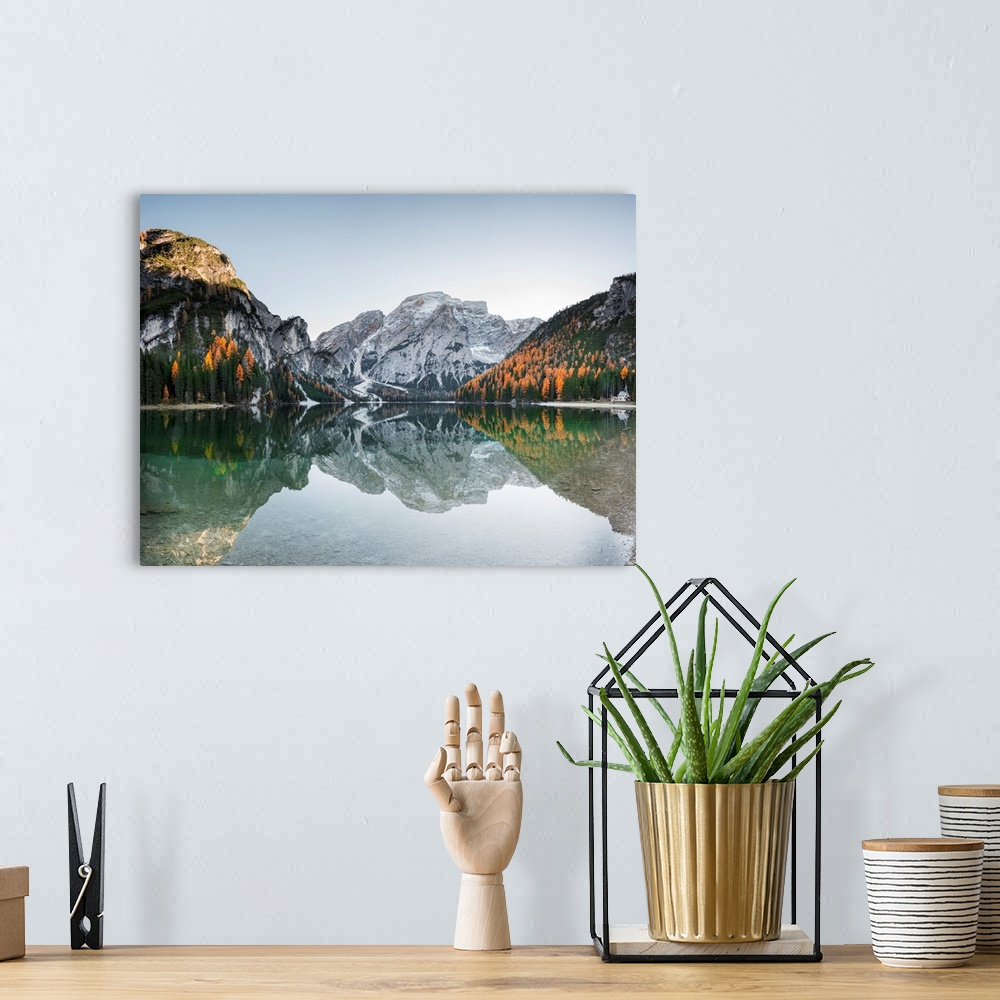 A bohemian room featuring Fine art photograph of the snowy mountains in Italy reflected in Braies lake.