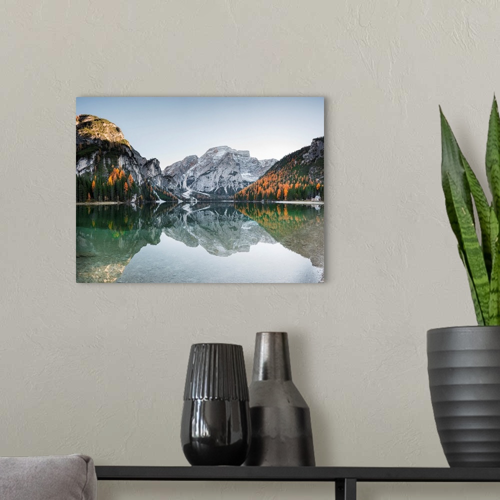 A modern room featuring Fine art photograph of the snowy mountains in Italy reflected in Braies lake.