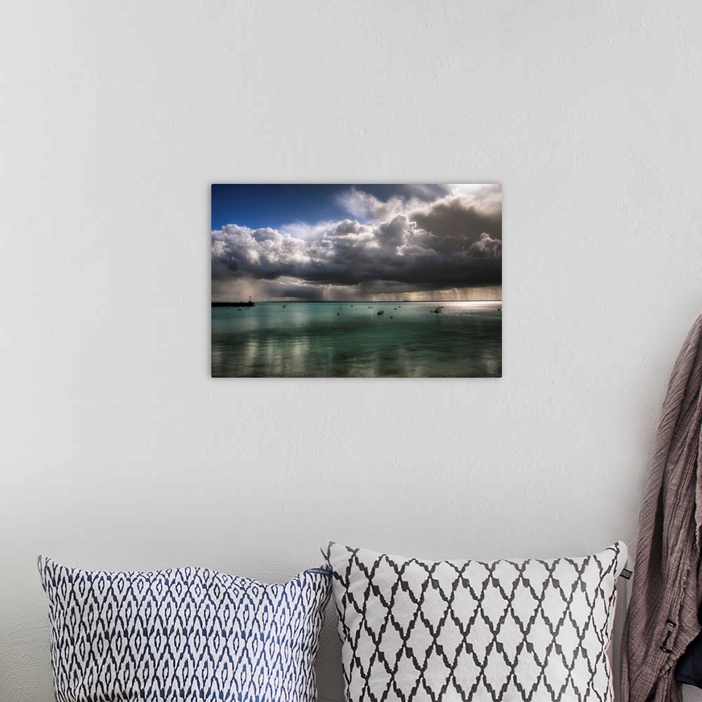 A bohemian room featuring An epic photograph of a swarm of large dense clouds moving over the French coast.