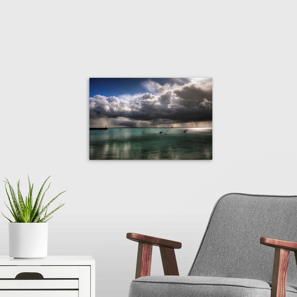 A modern room featuring An epic photograph of a swarm of large dense clouds moving over the French coast.