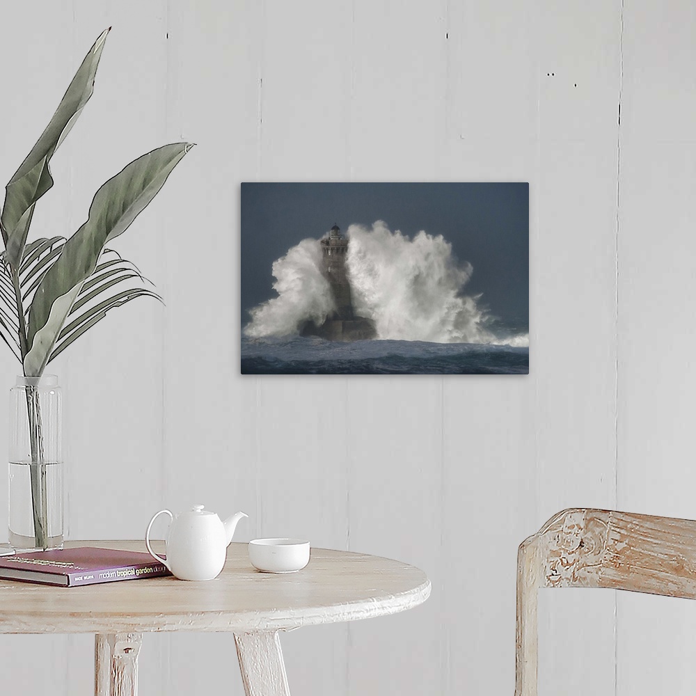 A farmhouse room featuring A photograph of a lighthouse in France being hit with crashing waves.