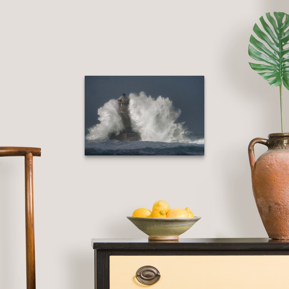 A traditional room featuring A photograph of a lighthouse in France being hit with crashing waves.