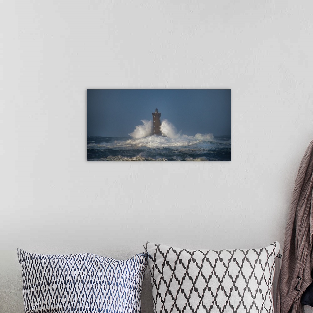 A bohemian room featuring A photograph of a lighthouse in France being hit with crashing waves.