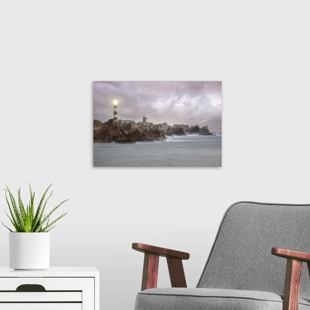 A modern room featuring A photograph of a lighthouse on the coast of France.