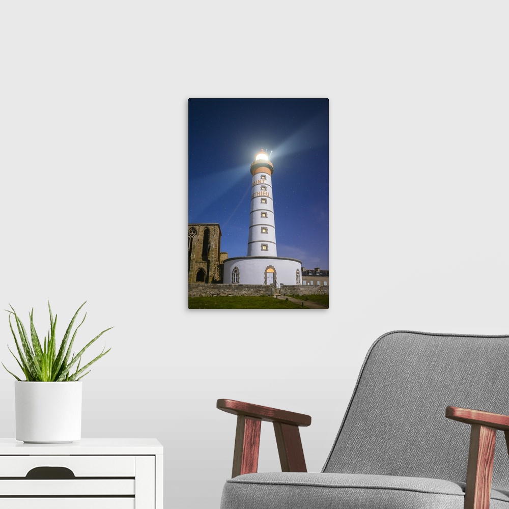 A modern room featuring A photograph of a lighthouse on the coast of France.