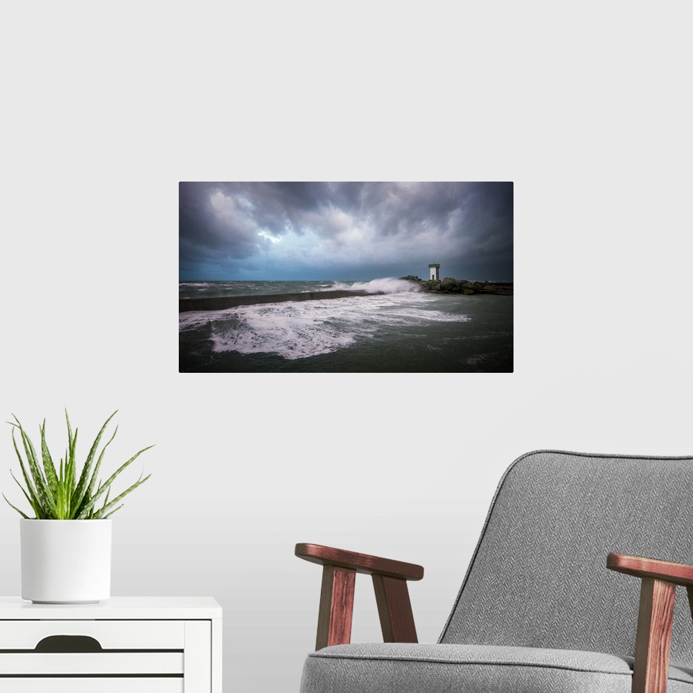 A modern room featuring A photograph of the French coast with a lighthouse in the distance under a sky filled with ominou...