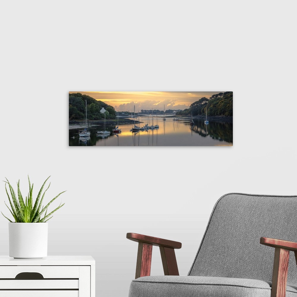 A modern room featuring Sailboats in the harbor of the Wrac'h river in a small fishing village in France at sunset.