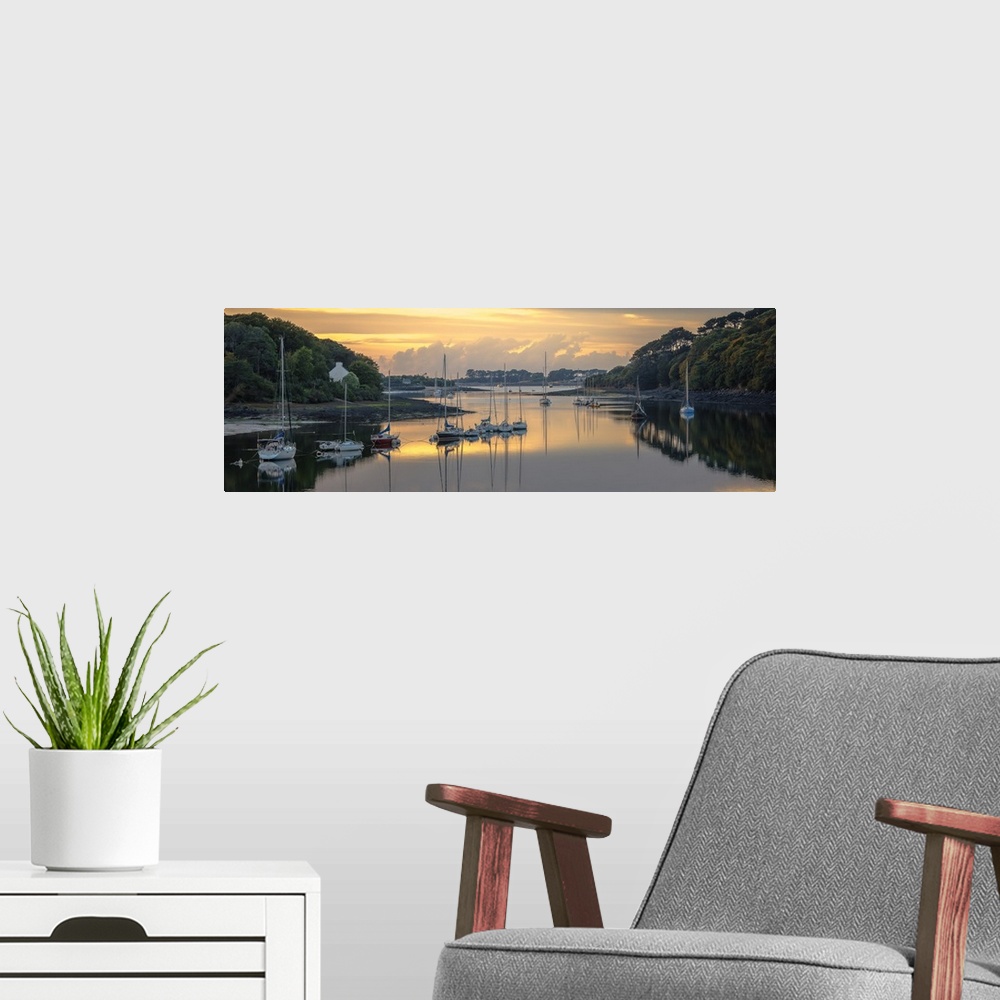 A modern room featuring Sailboats in the harbor of the Wrac'h river in a small fishing village in France at sunset.