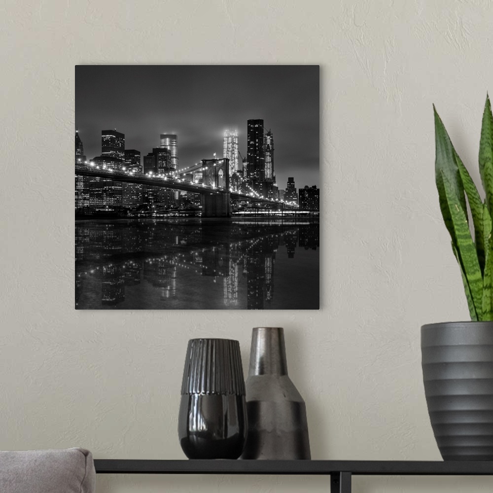 A modern room featuring Black and white photograph of New York city's skyline at night with the Brooklyn bridge in the fo...