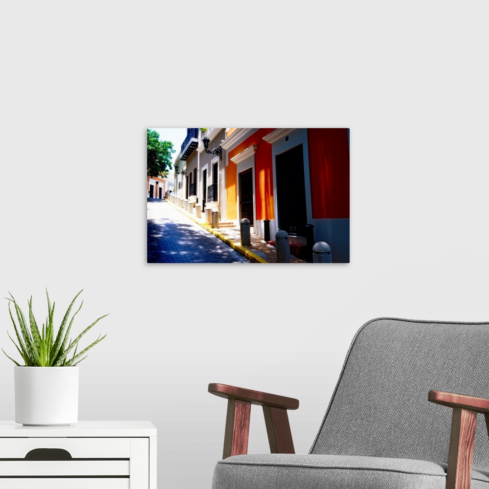A modern room featuring A photograph taken from the bottom of a steep street with small buildings sitting on the right si...