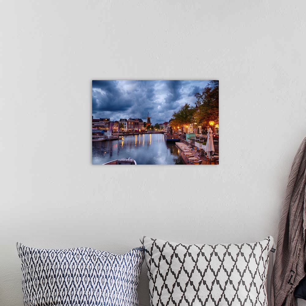 A bohemian room featuring Canal and windmill in Leiden at night, Netherlands.