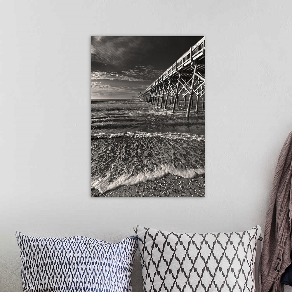 A bohemian room featuring Black and white image of a pier leading into the ocean on a cloudy day.
