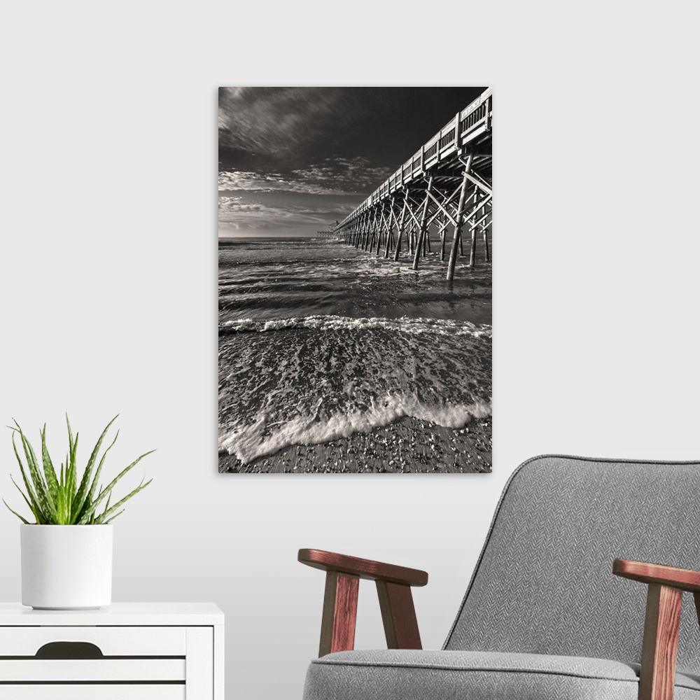 A modern room featuring Black and white image of a pier leading into the ocean on a cloudy day.